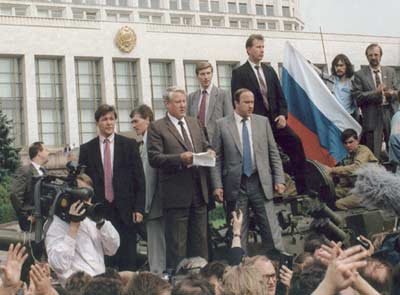 Boris Yeltsin (holding papers), the first Russian President, surrounded by defenders of the Russian government headquarters during the failed hard-line Communist coup attempt on August 19, 1991.